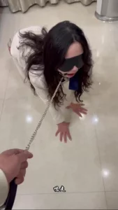 一位穿着职业装的成熟年轻女子被拴上狗链，接受SM训练，她的嘴像母狗一样被